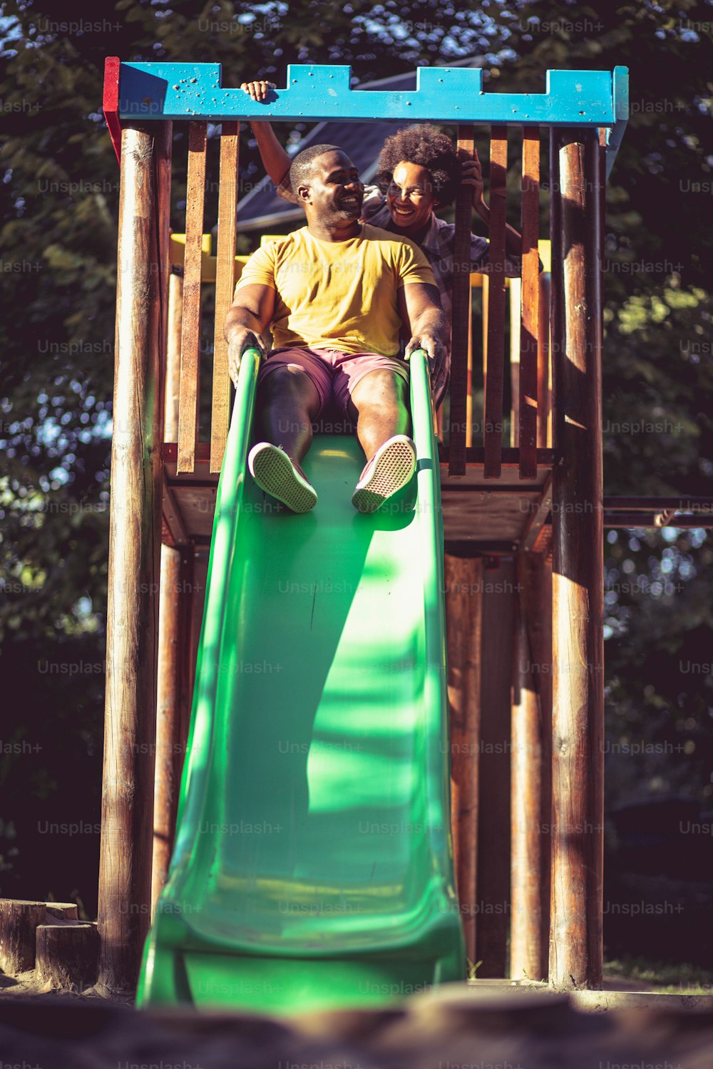 Casal afro-americano brincando no playground.