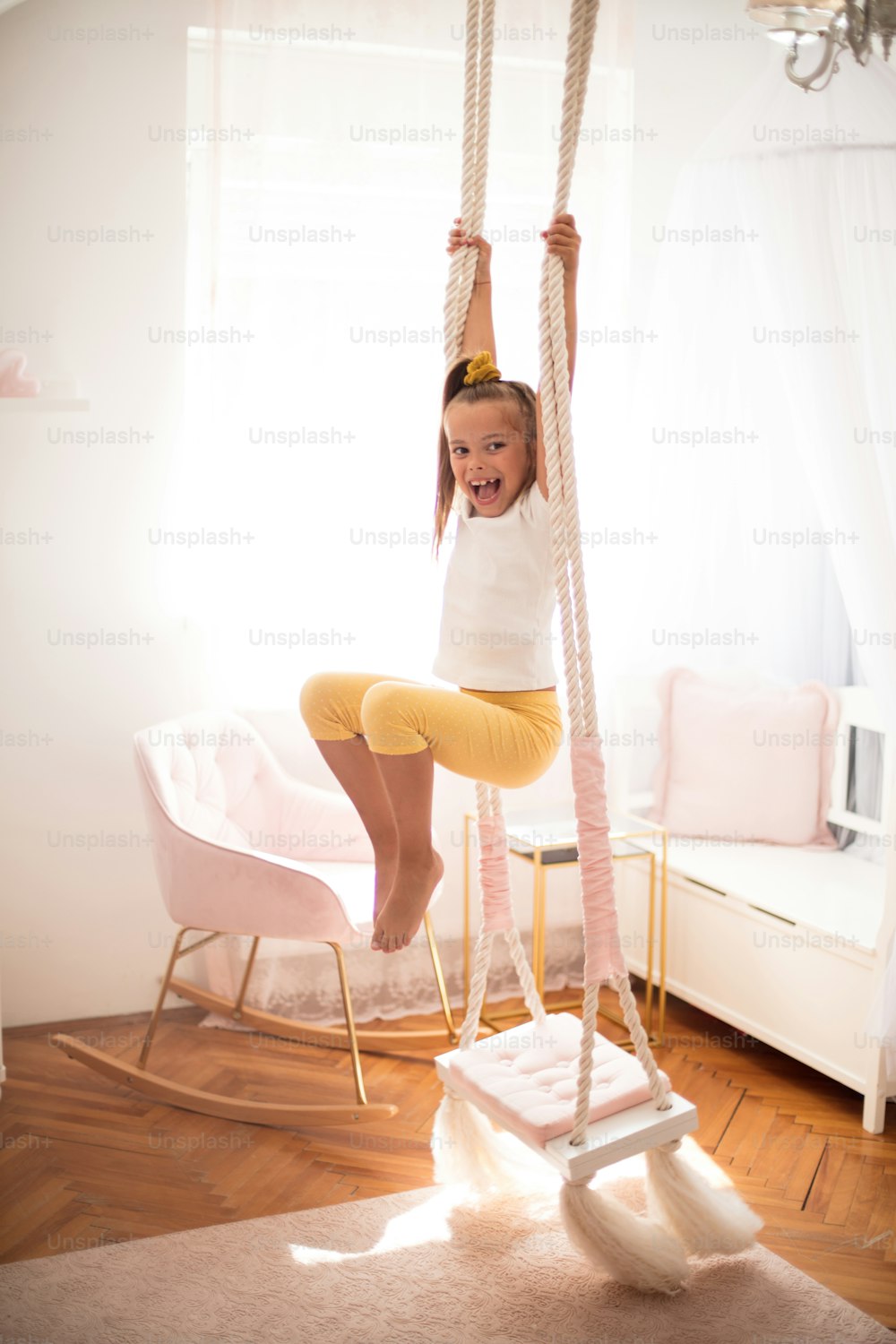 Little girl having exercise on swing.