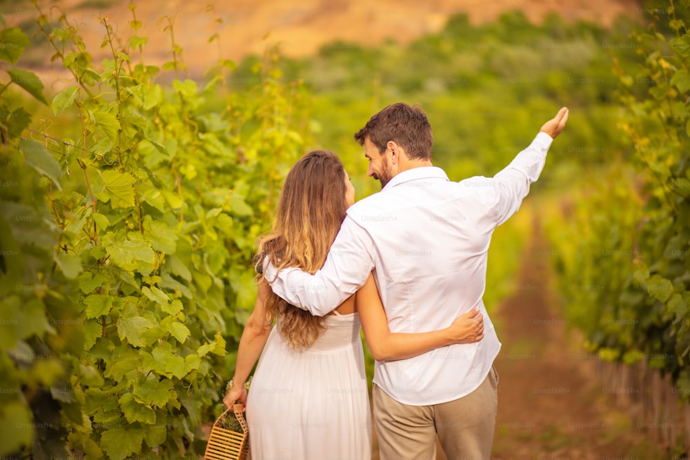 Couple walking and talking in vineyard.
