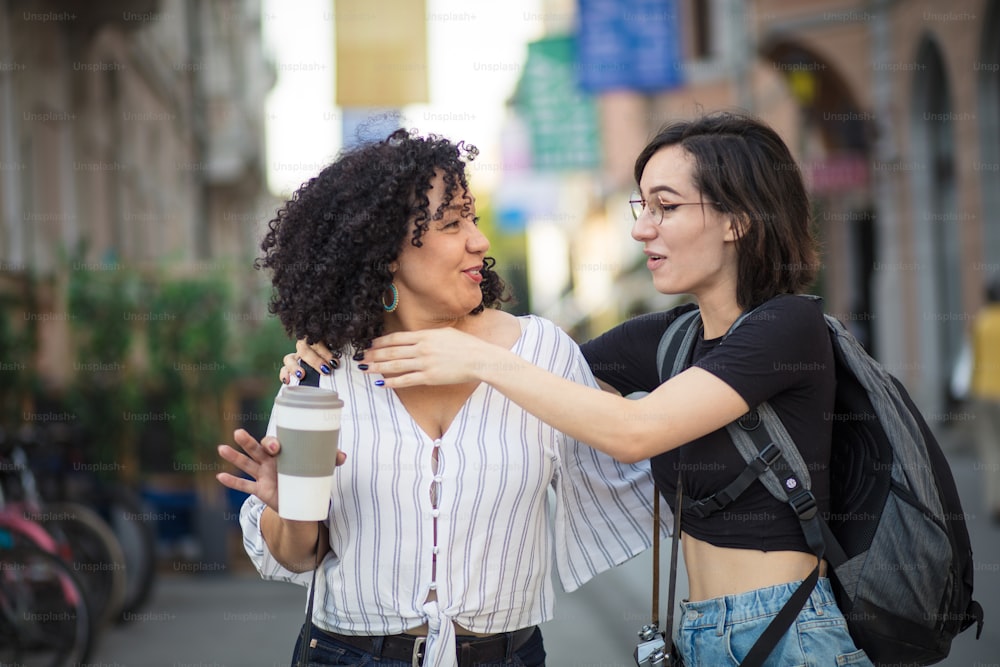 Two tourist women talking on street.