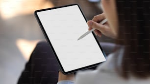 Cropped shot of young female holding mock up blank screen digital tablet while working, clipping path