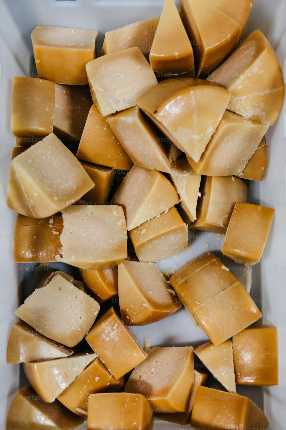 Details from traditional cheese and dairy production factory. Pieces of sliced delicious cheese ready for packing.