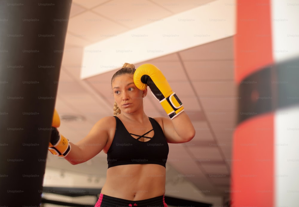 Una donna in forma che si allena con un sacco da boxe.