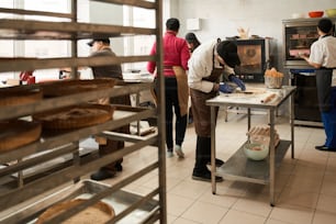 Processus de cuisson. Vue en pied de la cuisine avec des ouvriers préparant une délicieuse boulangerie pour le salling. Chacun est occupé par son propre processus. Banque d’images
