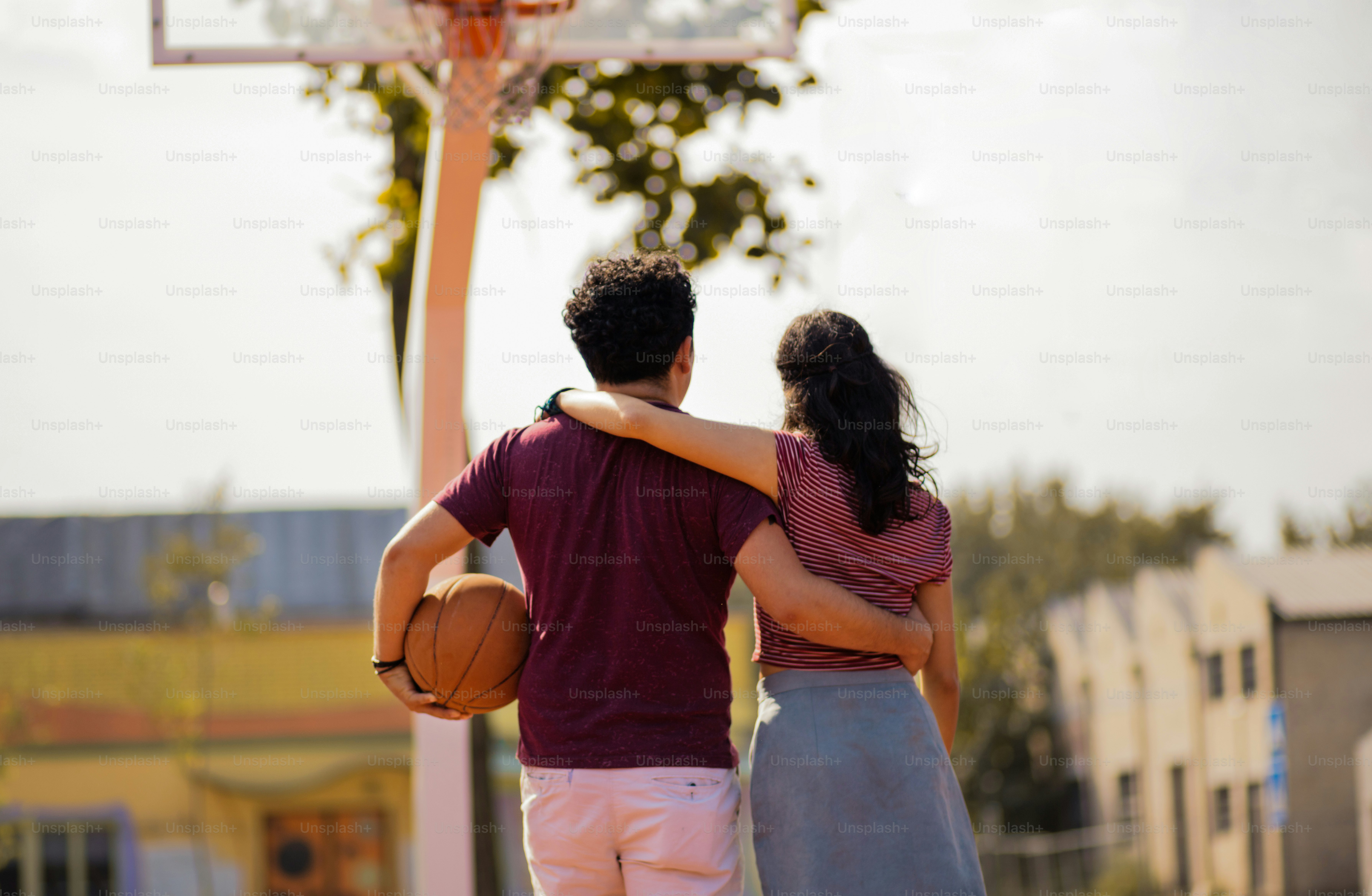 Couple avec ballon sur le terrain de basket-ball.