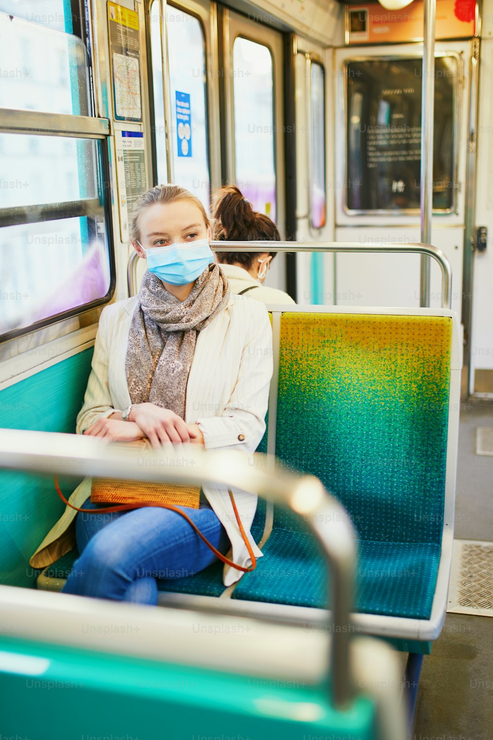 Girl travelling in a train of Parisian underground, wearing protective face mask during coronavirus outbreak. Pandemic and lockdown in France. Tourist spending vacation in France during pandemic