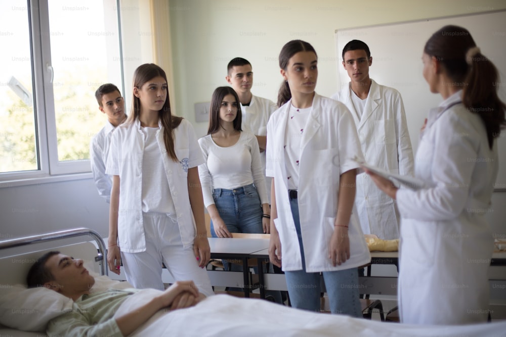 Medizinische Ausbildung.  Eine Krankenschwester demonstriert einer Gruppe von Krankenpflegeschülern die medizinische Schaufensterpuppe.