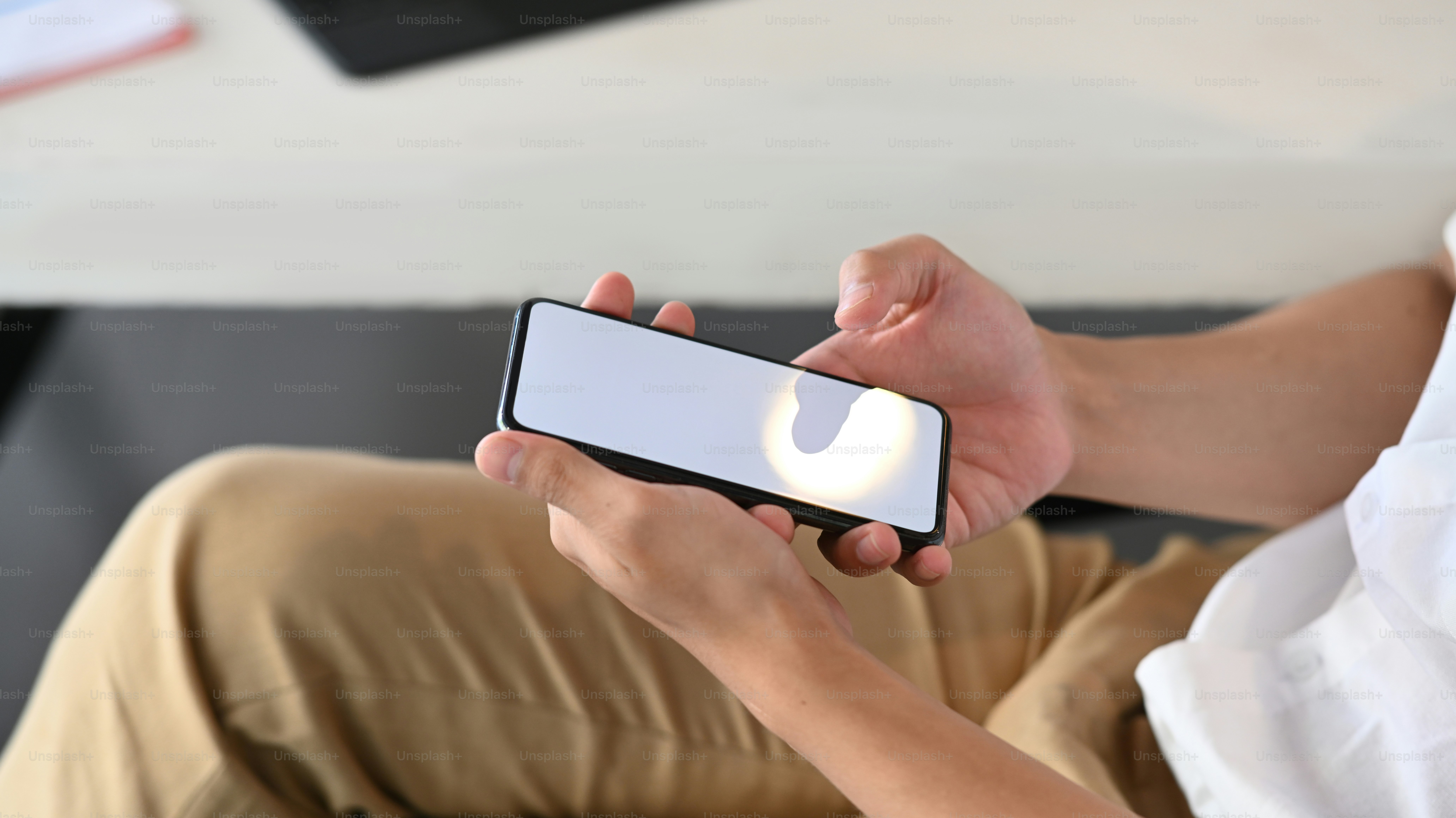Close up view of casual man using smart phone for texting or massaging.