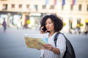 地図を見ている観光客。路上で地図を読んだり、電話で話したりする観光客。