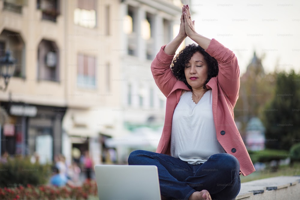 Business woman working yoga on the street.