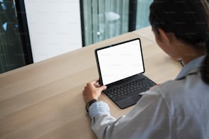 Rear view of young woman employee working with computer table in office room.