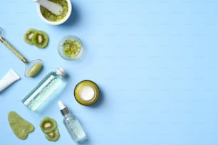 Natural organic SPA cosmetic products set with sliced kiwi fruit. Top view herbal skincare beauty products on blue background. Banner mockup for beauty salon