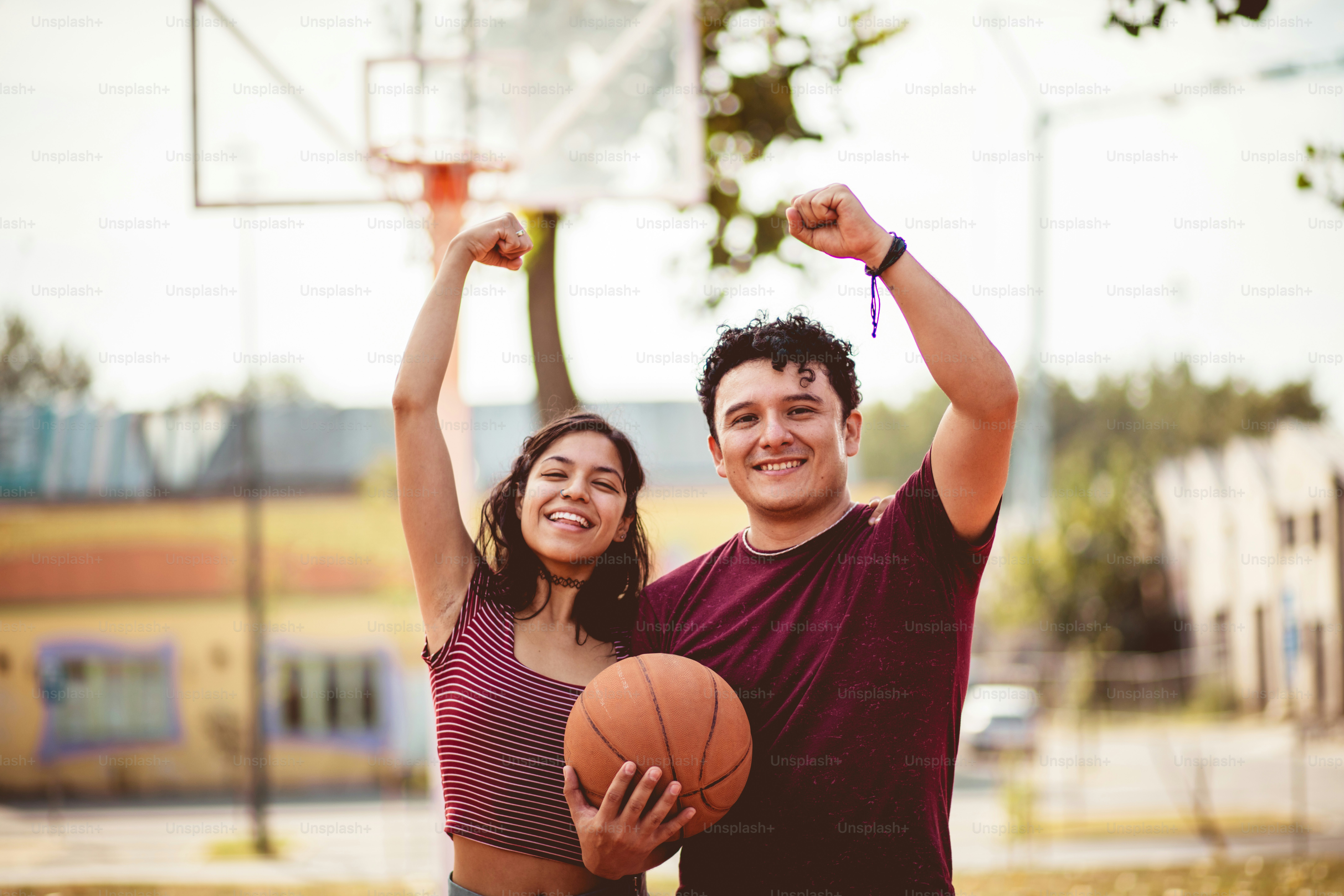 Jeune couple jouant au basket-ball.