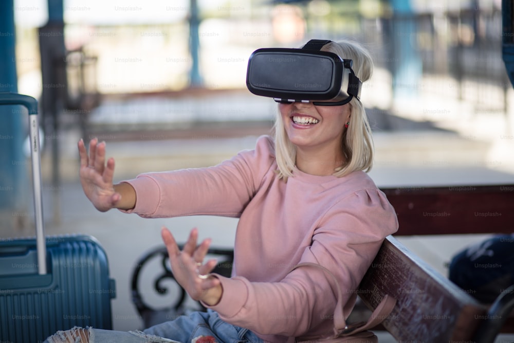 Woman on bus station. Young woman touching experiencing VR helmet.