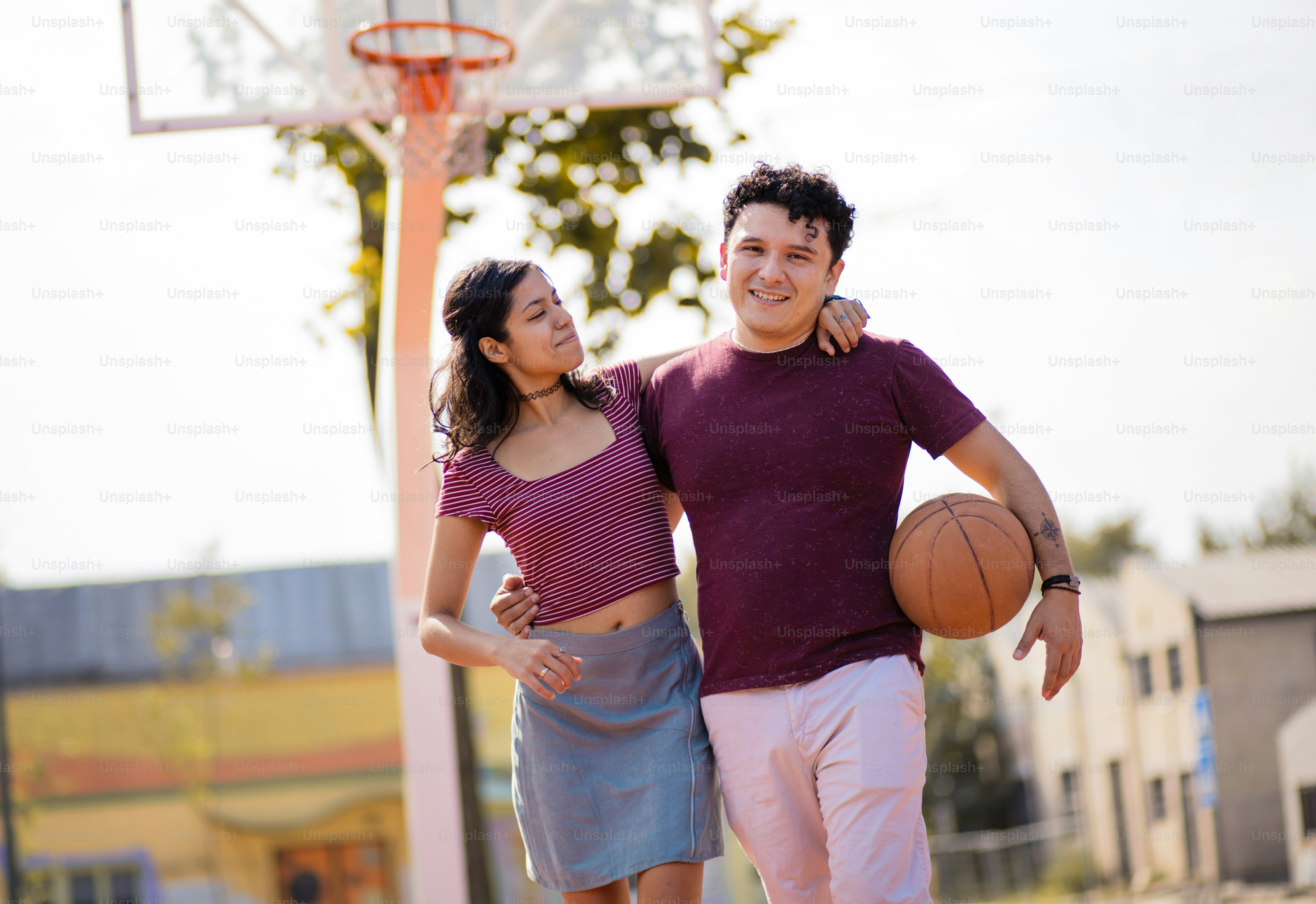 Couple avec ballon sur le terrain de basket-ball.