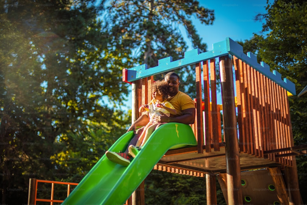 African American father having fun outdoors with his daughter.