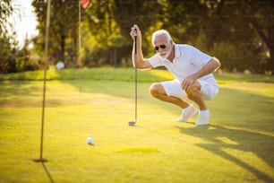 Senior man playing golf alone.