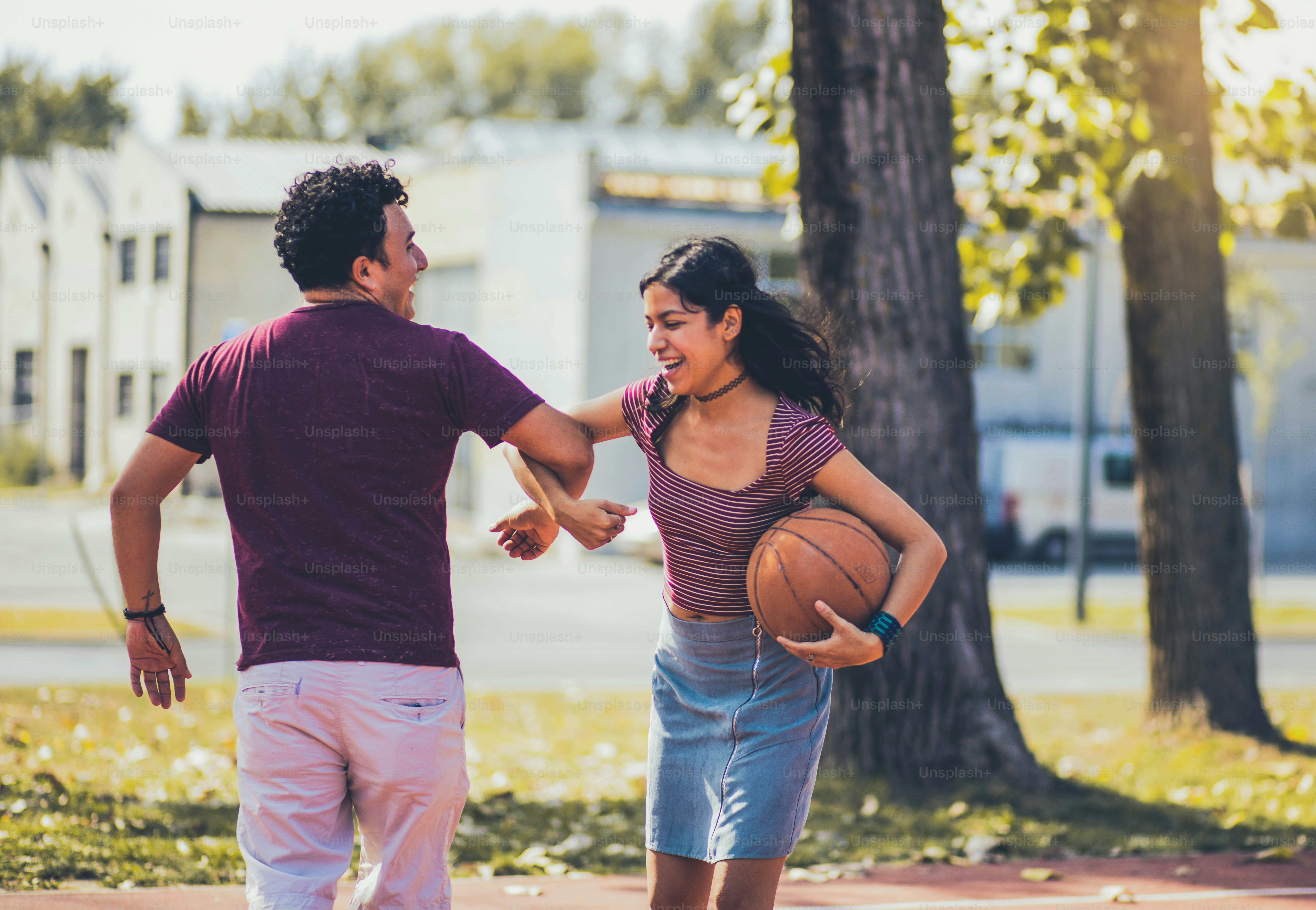 Jeune couple jouant au basket-ball.