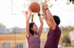 Couple standing on court. Woman holding ball for basket.