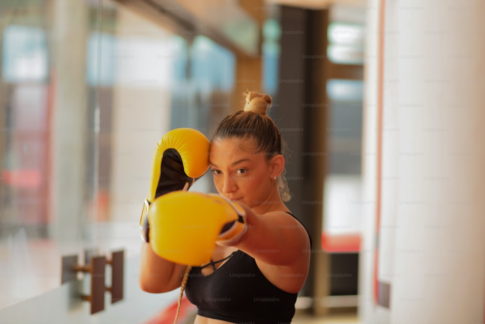 Mulher boxer em luvas de boxe. O foco está no plano de fundo.