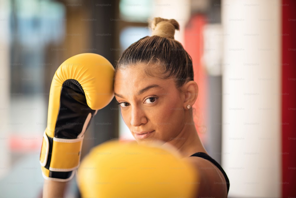 Boxer woman in boxing gloves. Focus is on background.