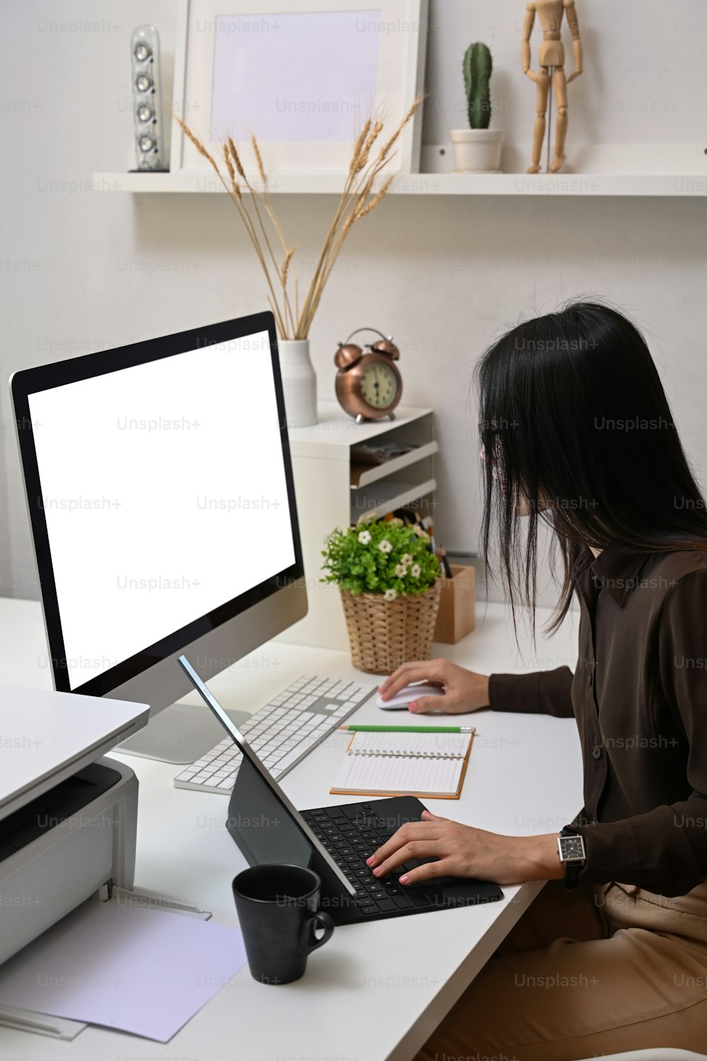 L'impiegata della giovane donna si concentra sul lavoro al computer in ufficio.