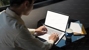 Side view of concentrate businessman working on computer laptop at office.
