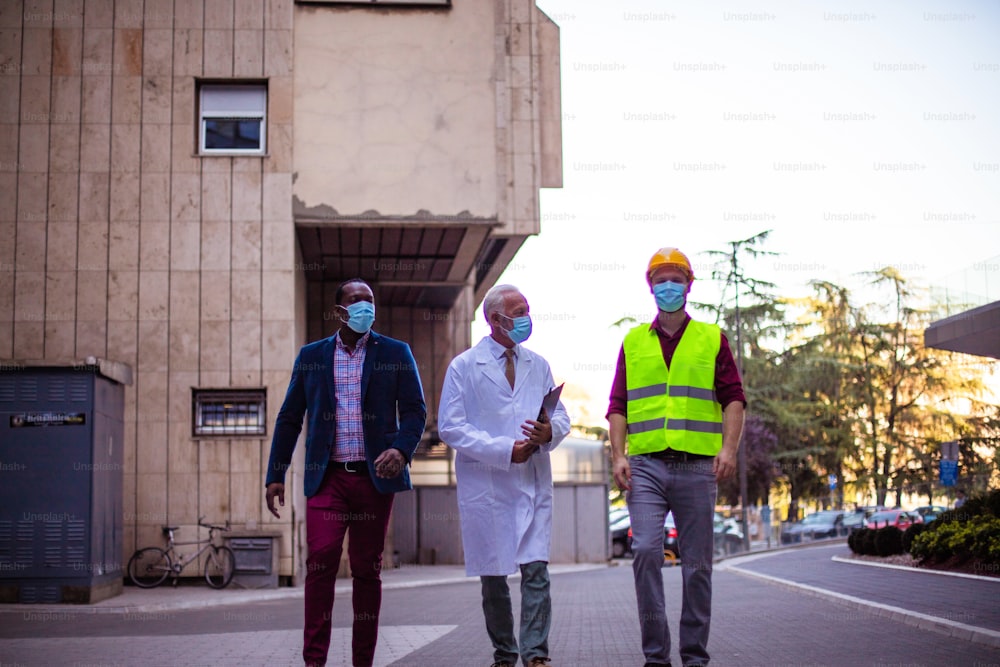 Business man, doctor and engineer walking trough street.