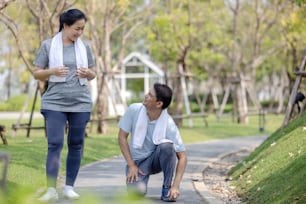 Smiling senior active couple exercise jogging together in the park"n