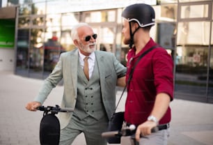Two business men riding electric scooter in the city.