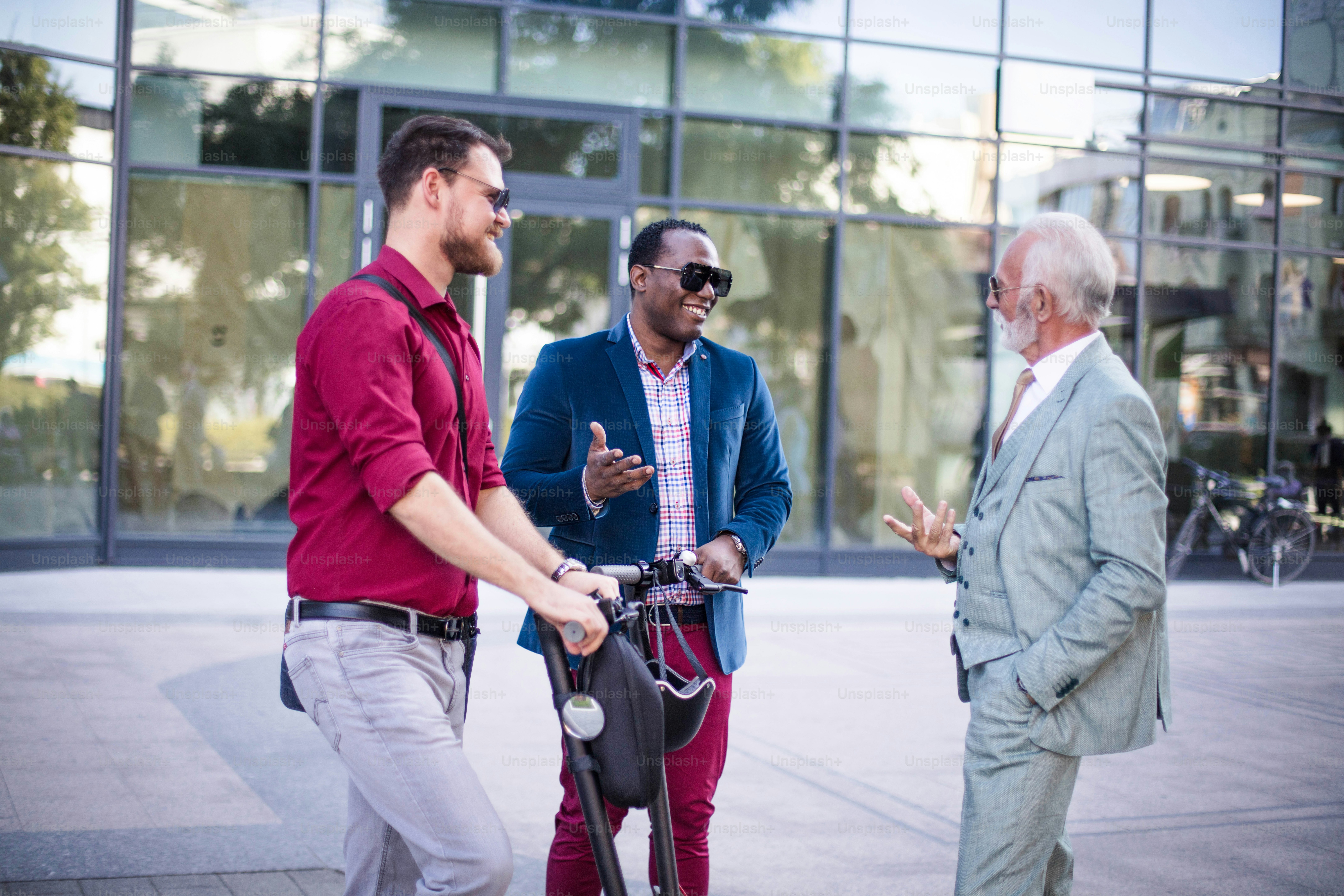 Three business colleagues standing outdoors and discussing.