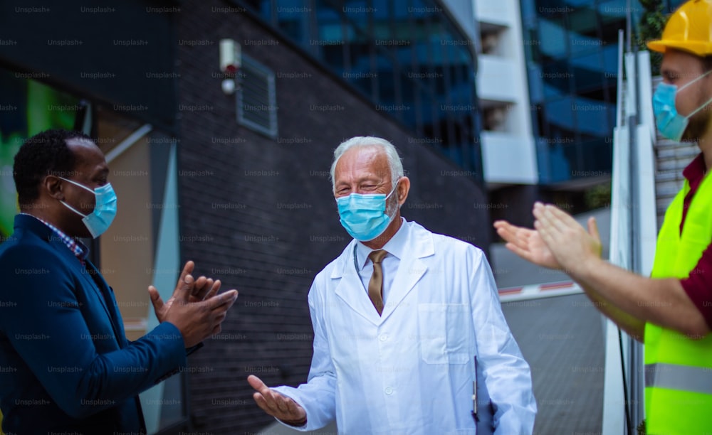 Homme d’affaires, médecin et ingénieur discutant dans la rue.