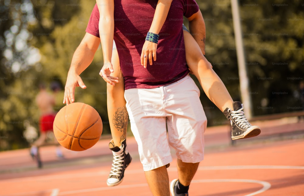 Junges Paar beim Basketballspielen.