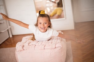 Smiling little girl in bedroom alone. Looking at camera.