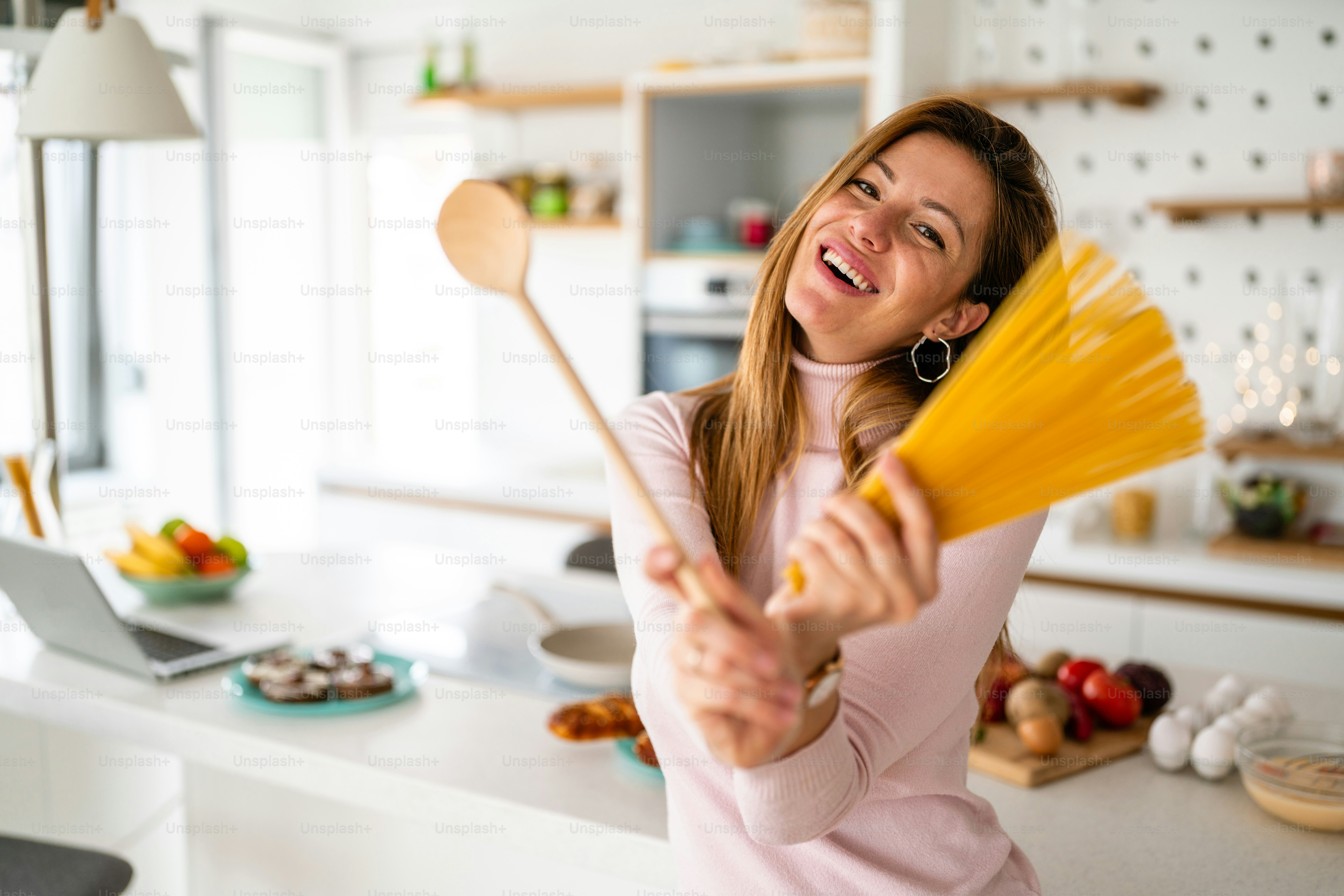 Schöne glückliche Frau, die Spaß in der Küche zu Hause hat