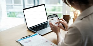 Close up of woman calculating financial or taxes or household on calculator, female calculate while sitting at her home and make payment