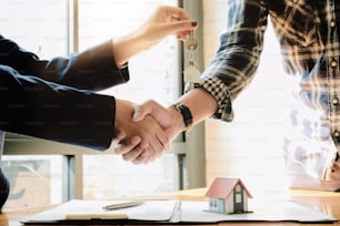 Real estate agent and customers shaking hands together celebrating finished contract after about home insurance and investment loan, handshake and successful deal