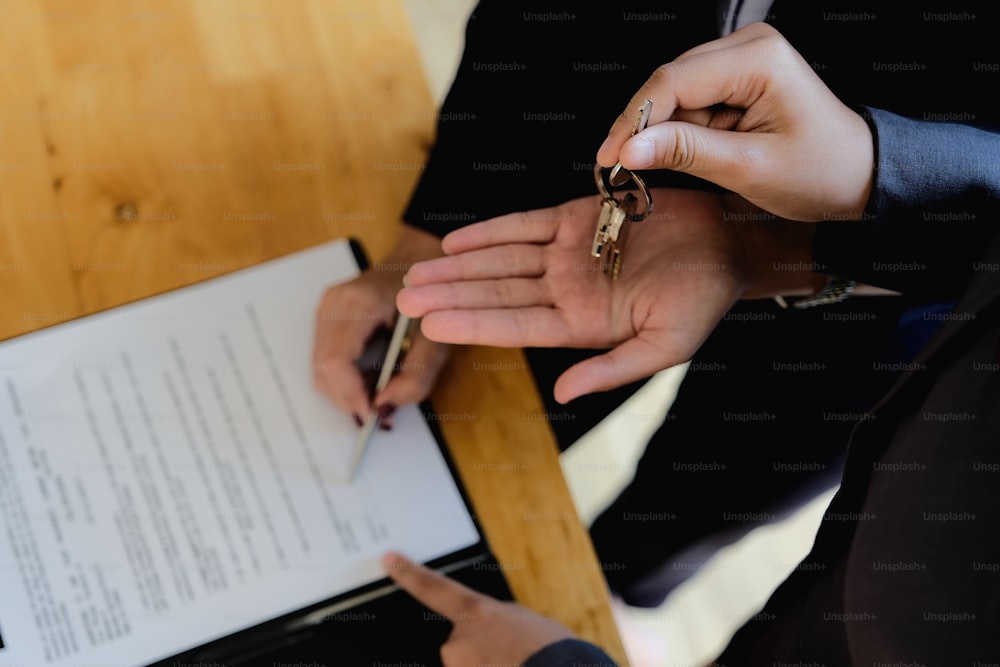 부동산 중개인은 주택 구매 또는 판매에 대한 고객 서명 계약 서명에 손을 제공합니다. 부동산 개념 접촉 계약 개념
