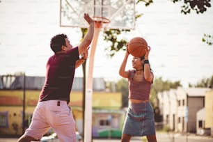 Pareja joven jugando al baloncesto.