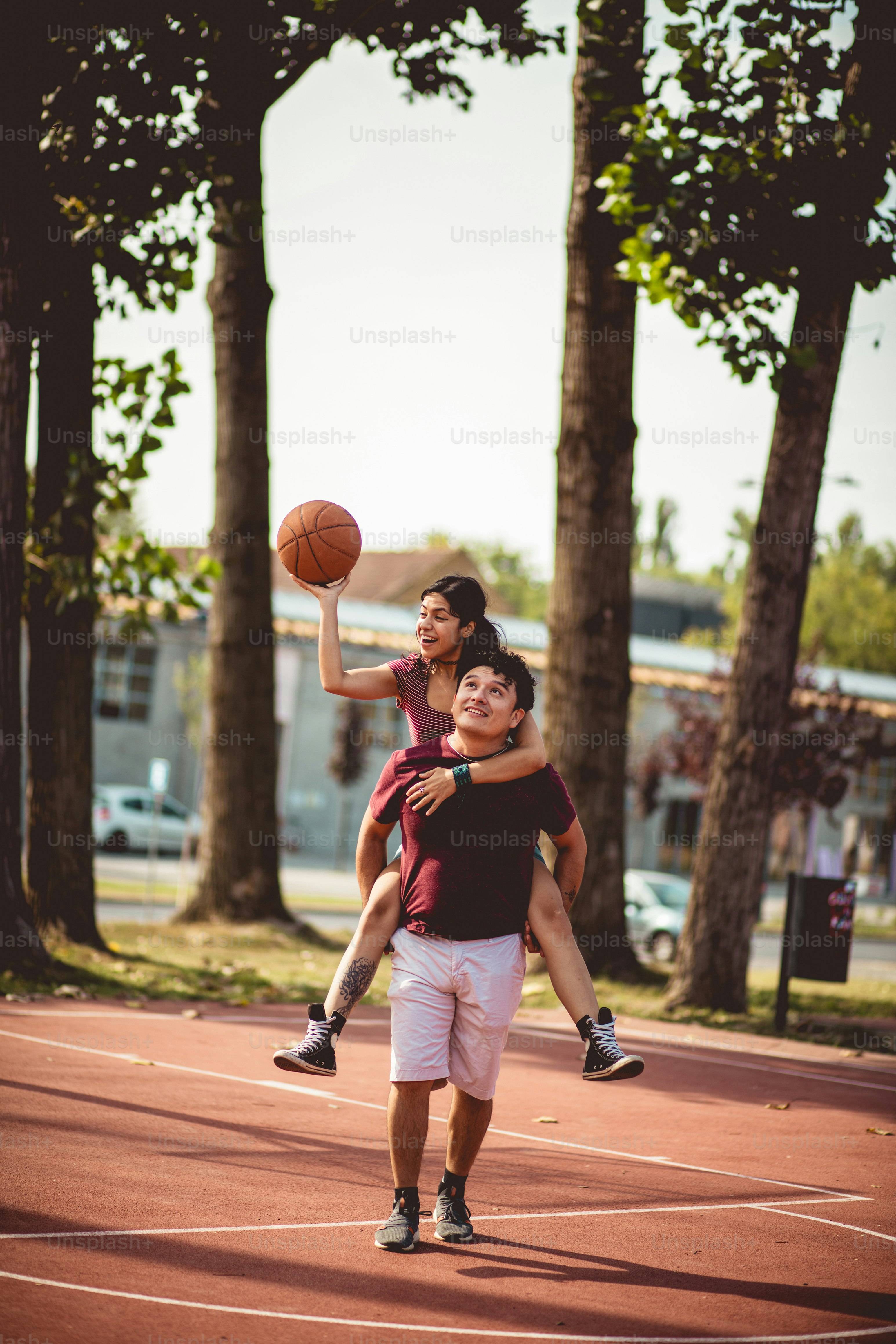 Jeune couple jouant au basket-ball.