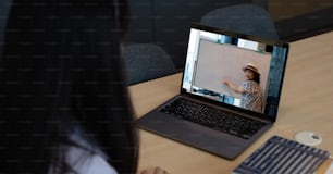 Asian young girl student learning virtual internet online class from school teacher by remote meeting due to covid pandemic. Female teaching by using headphone and whiteboard.