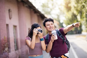 Young couple standing on street. Girl uses a camera.