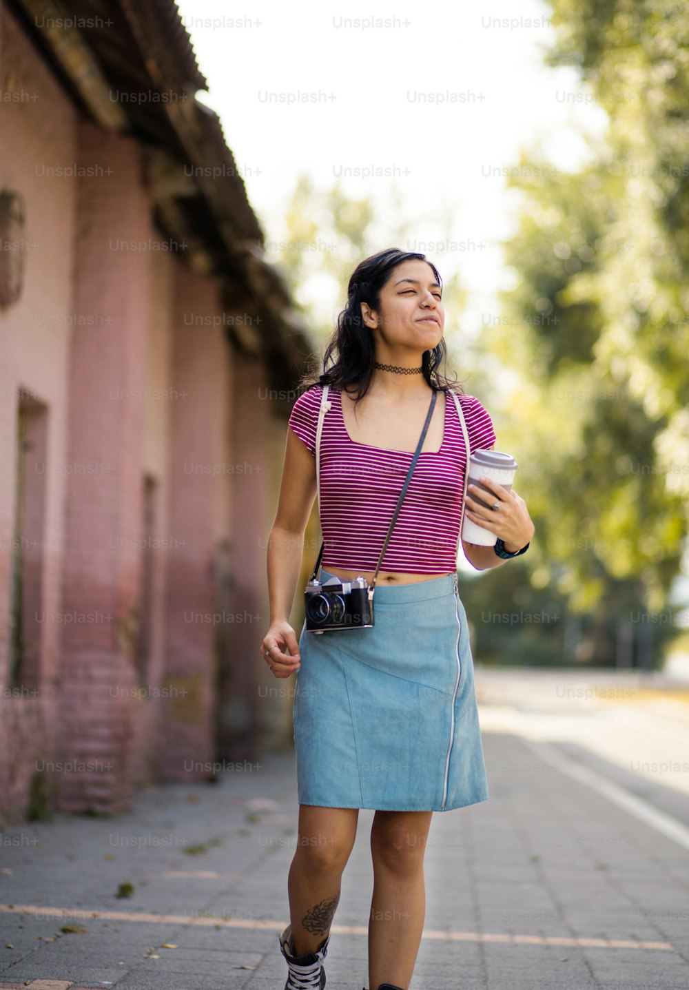 Girl walking trough street with camera.