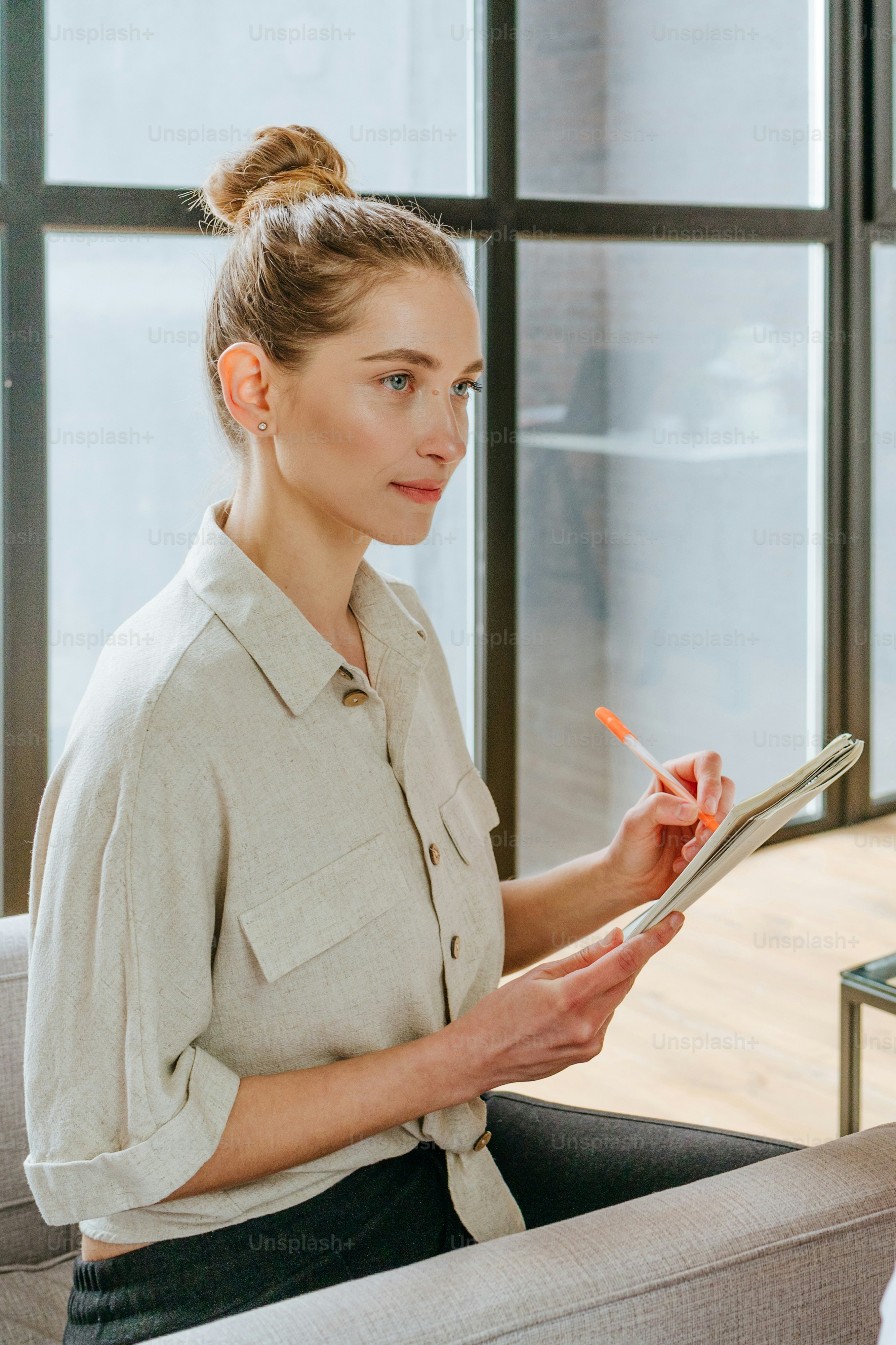 Young woman writing something in the notebook. Selective focus.