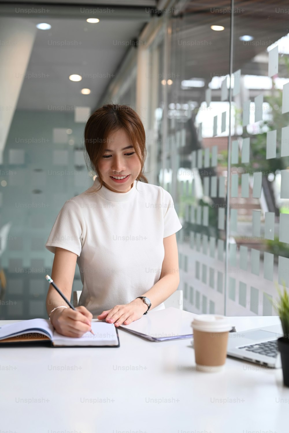 Portrait of happy businesswoman smiling and working in modern office.