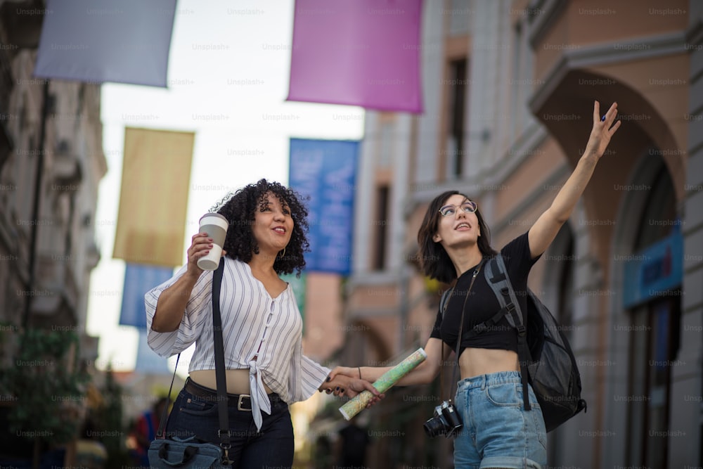 Two happy tourist women on street.