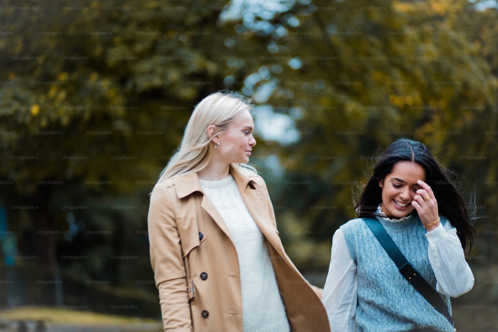 Two girls walking trough park and talking.