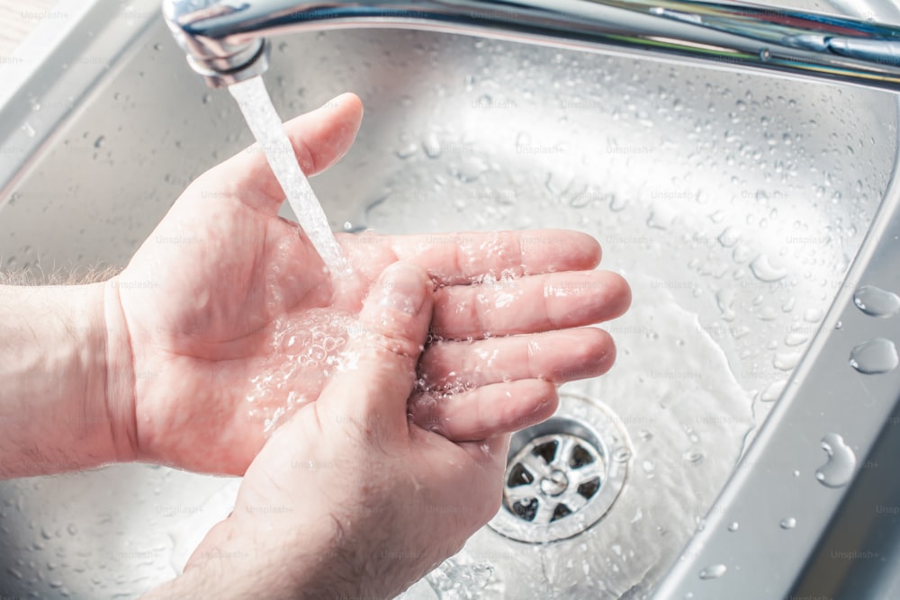 Male Washing Hands Under Water Stream At A Kitchen Sink