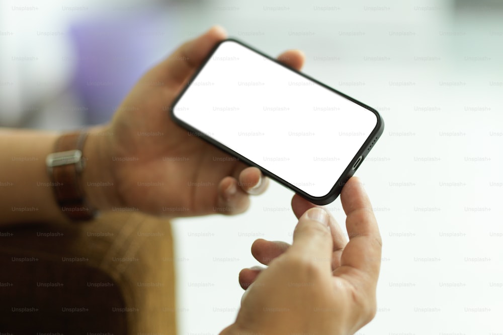 Abgeschnittene Aufnahme eines männlichen Smartphones mit horizontalem Mock-up-Bildschirm im verschwommenen Hintergrund, Beschneidungspfad