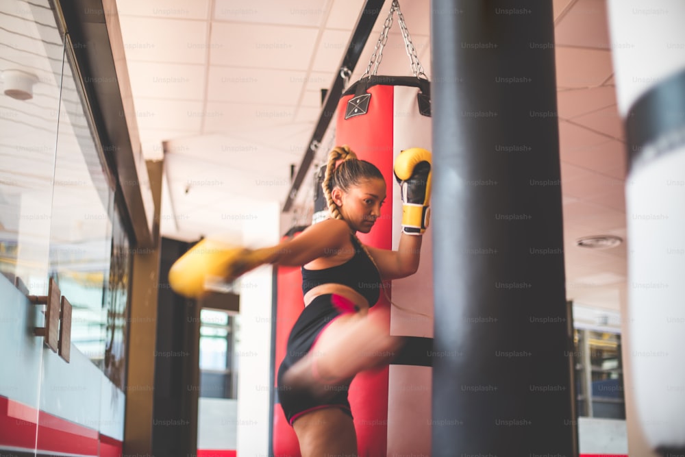 Woman boxer punching bag.